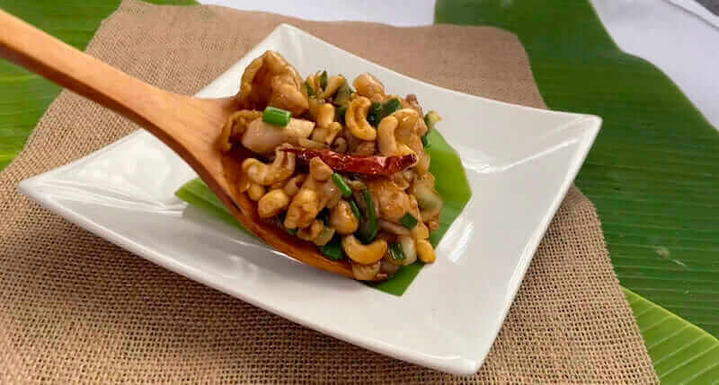 serving thai cashew chicken with wooden spoon